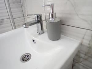 a bathroom sink with a faucet and a cup on it at Apartman Edwin Jajce in Jajce +44 photos
