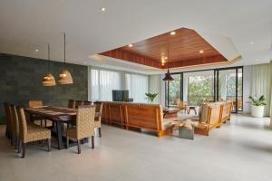 a dining room with a table and a couch at Atsuka Hill View Villa 8 bedrooms with a private heated swimming pool in Bandung