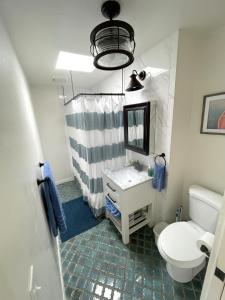 a bathroom with a sink and a toilet and a mirror at Redwood Hollow Cottages in San Diego +116 photos