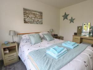 a bedroom with a bed with towels on it at Benllech Bay Cottage in Benllech