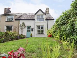 una casa con una porta verde in un cortile di Ivy Cottage a Harlech