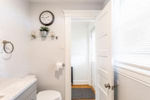 a bathroom with a toilet and a clock on the wall at Spacious&Gracious- 5BR Fam-Friendly near I95&Shops in Fairfield +122 photos