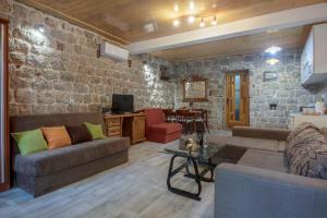 a living room with a couch and a stone wall at Hidden Gem Apartment of the Old Street in Risan