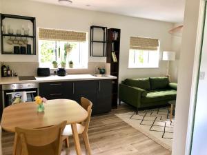 a kitchen and living room with a table and a green couch at Linden Suite in Goring