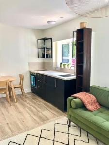 a kitchen with a green couch and a table at Linden Suite in Goring +46 photos