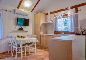 a kitchen with a table with chairs and a television at Pure Nature Haven By The Sea with Hot Tub in Rovinj
