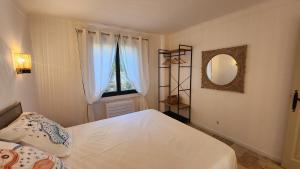 a bedroom with a bed and a mirror and a window at Villa Argonaute in Saint-Tropez
