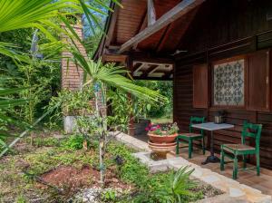 a patio with two green chairs and a table at Pure Nature Haven By The Sea with Hot Tub in Rovinj