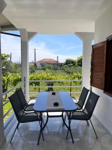 a patio with a table and chairs on a balcony at Sea and Sand House in Orfánion