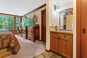 a bedroom with a bed and a sink and a mirror at Everline Resort & Spa 701 & 703 in Olympic Valley +30 photos