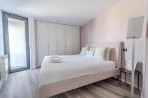 Un dormitorio con una gran cama blanca y una gran ventana. en The Locomotive Flat by House and People, en Braga