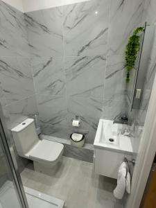 a bathroom with a white toilet and a sink at On the Beach Retreat in Bournemouth +39 photos