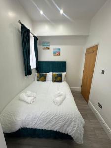 a bedroom with a bed with two towels on it at On the Beach Retreat in Bournemouth