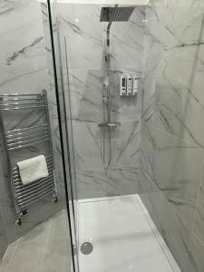 a shower with a glass door in a bathroom at On the Beach Retreat in Bournemouth