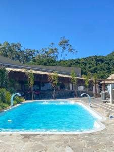 una piscina frente a una casa en Mansão Fazendinha para grupos Arraial do Cabo, en Arraial do Cabo