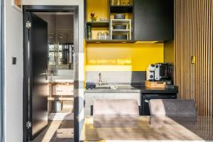 a kitchen with yellow walls and a table and chairs at Tainer 'nco in Appelscha +17 photos