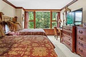 a bedroom with two beds and a desk and a television at Everline Resort & Spa 701 & 703 in Olympic Valley