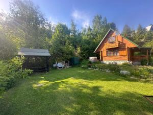 un gran patio con una casa de madera en el fondo en Chata Retro, en Stará Lesná