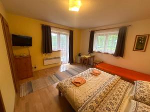 タトランスカ・ロムニツァにあるPenzion Pažickýのベッド2台と薄型テレビ付きのベッドルーム