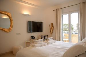 a bedroom with a bed with towels on it at The White Knight Premium Boutique Hotel in Għajnsielem