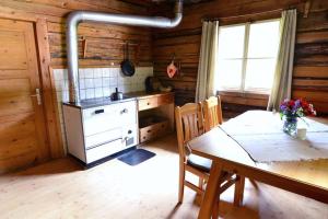 a kitchen with a table and a stove in a cabin at Peintnerhof Almhütte in Innervillgraten
