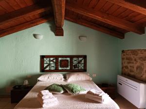 a bedroom with a bed with pillows and a window at Is Antas in Orroli