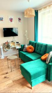 a living room with a green couch and a table at M&M Doki Studio in Gdańsk