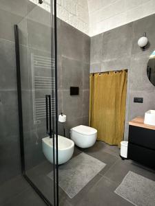 a bathroom with a toilet and a glass shower at Casa Rara al Mare in Monopoli