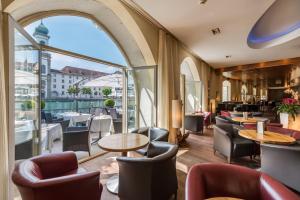 a restaurant with tables and chairs and a large window at Hotel des Balances in Lucerne