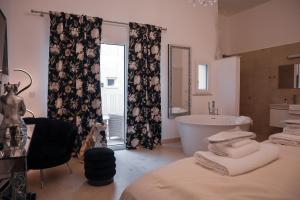 a bathroom with a bath tub and a sink at The White Knight Premium Boutique Hotel in Għajnsielem