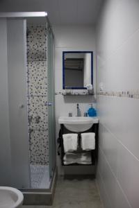 a white bathroom with a sink and a shower at Andanzas Bahia Uni in Bahía Blanca +70 photos