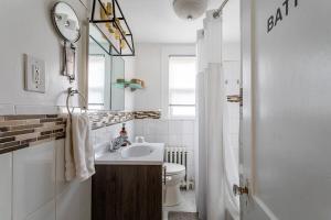 a bathroom with a sink and a toilet and a mirror at Bella room near downtown Train I-95 & beaches in Stamford +52 photos