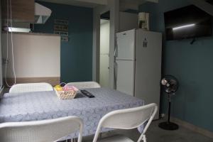 a kitchen with a table with chairs and a refrigerator at Andanzas Bahia Uni in Bahía Blanca