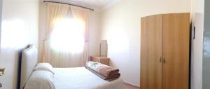 sypialnia z łóżkiem i dużym oknem w obiekcie HoTEL AFOULKI w mieście Tafraout