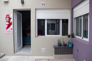 an open door of a house with potted plants at Andanzas Bahia Uni in Bahía Blanca