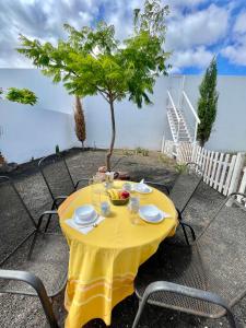 een tafel met een geel tafelkleed op een tafel met stoelen bij Loft La Cueva de los Pájaros in Playa Blanca