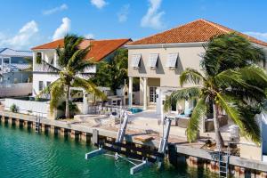 a villa with a dock and palm trees at Abundance and Prosperity Villa in Long Bay Hills