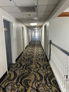 a hallway with a carpeted floor in an office building at Economy Suites - Tulsa Airport in Tulsa +23 photos