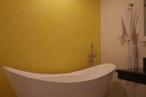 een badkamer met een ligbad en een gele muur bij Hilton MM Grand Hotel Puebla, Tapestry Collection in Puebla