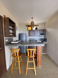 a kitchen with two bar stools and a counter top at The UFO Shore in Las Núñez