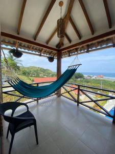 a room with two hammocks and a view of the ocean at The UFO Shore in Las Núñez