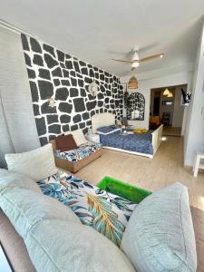 een woonkamer met een bank en een stenen muur bij Loft La Cueva de los Pájaros in Playa Blanca +19 foto's