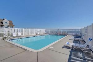 a swimming pool with chaise lounge chairs next to a building at Topsail Treasure's - Oceanfront Luxury Spa Pool in North Topsail Beach