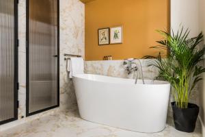 a bathroom with a large tub and a plant at Hôtel Chamar in Paris +41 photos