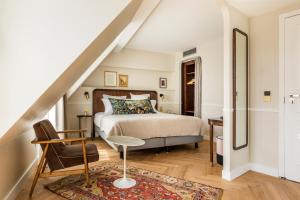 1 dormitorio con 1 cama y 1 silla en Hôtel Chamar en París