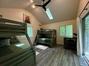 a room with two bunk beds and a ceiling fan at Family Glamping Cabin-Bed and Bear at Valley Bear Farms Resort in Balsam Grove