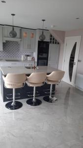 a kitchen with a counter and two stools at Suaimhneas in Gortahork +2 photos