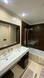 a bathroom with a sink and a large mirror at Rooms in Faro close to airport in Faro