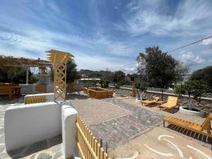 a patio with chairs and tables and a fence at Casa Piaduli in Faliraki