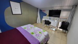 a bedroom with a bed and a crib and a tv at Oceano Azul Hospedagens a 50 M DA ORLA-Passarela do Caranguejo in Aracaju